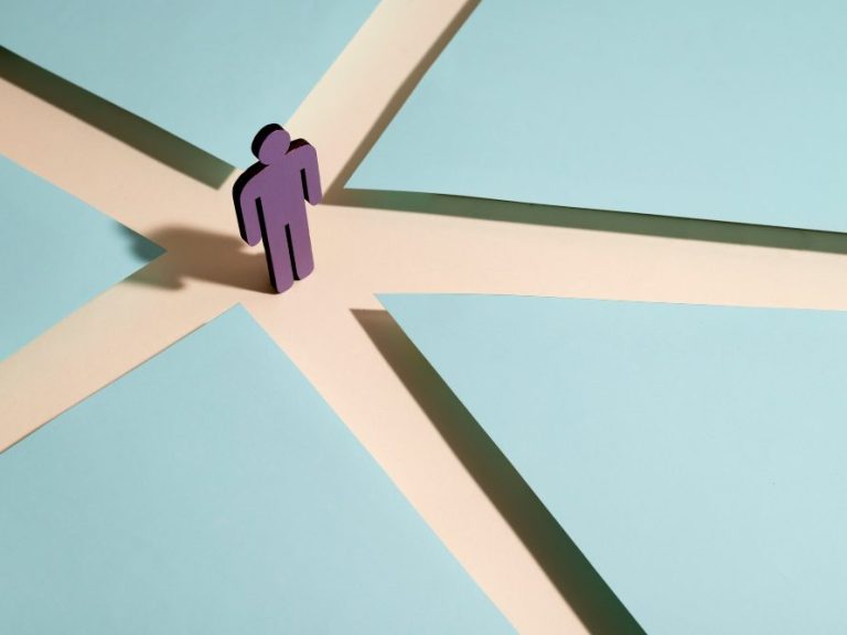 Eine lila Figur steht an einer Kreuzung und kann sich entscheiden verschiedene Wege zu gehen